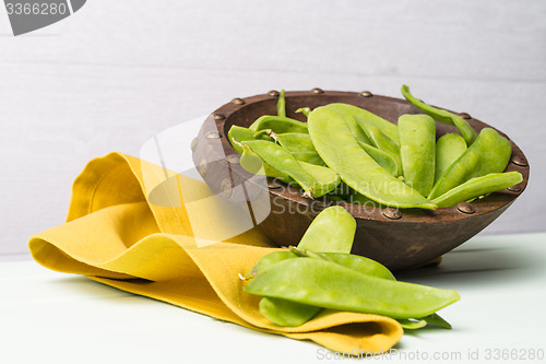 Image of Snow peas on wooden bowl