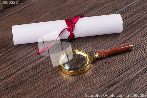 Image of Wrapped paper sheets and magnifying glass