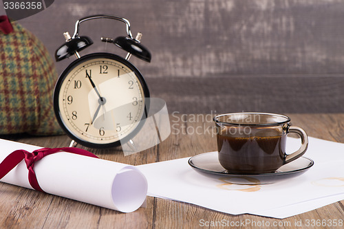 Image of Old clock, hat, coffee and paper sheets