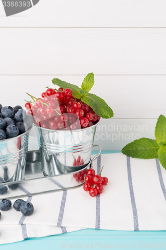 Image of Red currants and blueberries in small metal buckets