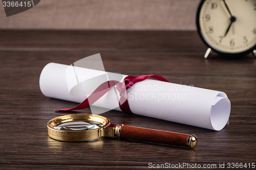 Image of Wrapped paper sheets and magnifying glass