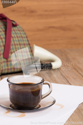 Image of Coffee cup, paper sheets and detective hat