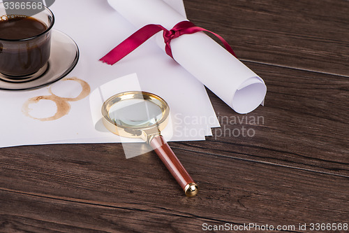 Image of Wrapped paper sheets and magnifying glass