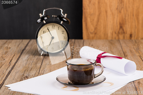 Image of Old clock, hat, coffee and paper sheets