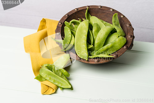 Image of Snow peas on wooden bowl