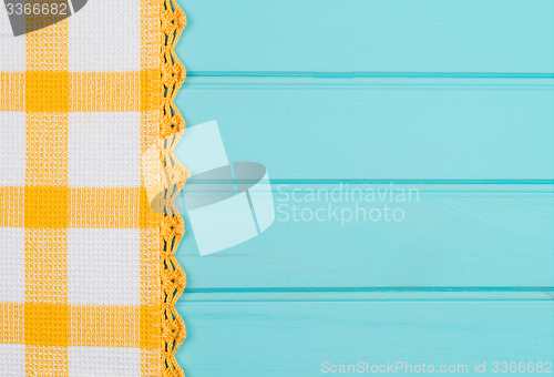 Image of White and yellow towel over wooden table
