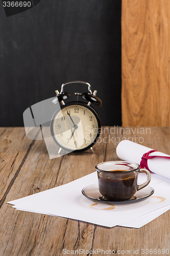 Image of Old clock, hat, coffee and paper sheets