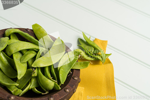 Image of Snow peas on wooden bowl