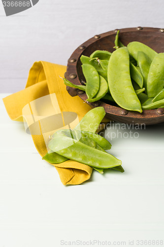Image of Snow peas on wooden bowl