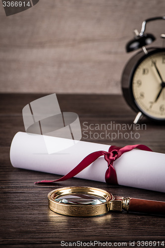 Image of Wrapped paper sheets and magnifying glass