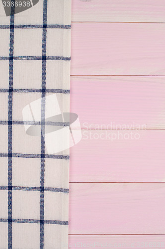 Image of White and blue towel over wooden table