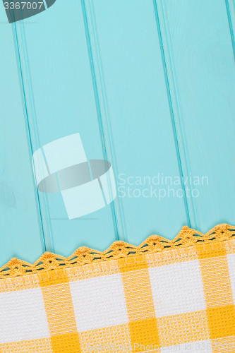 Image of White and yellow towel over wooden table