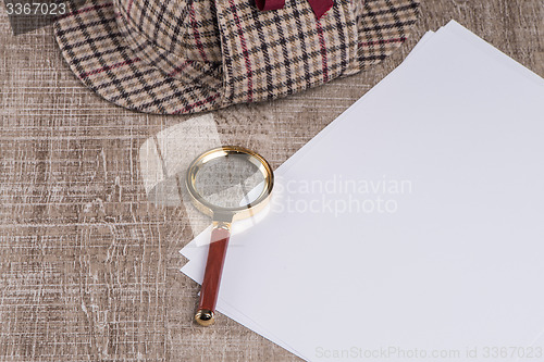 Image of Paper sheets and magnifying glass