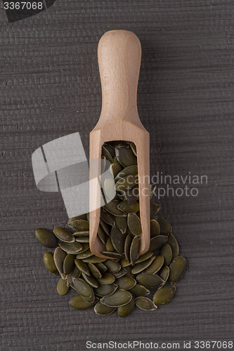 Image of Wooden scoop with pumpkin seeds