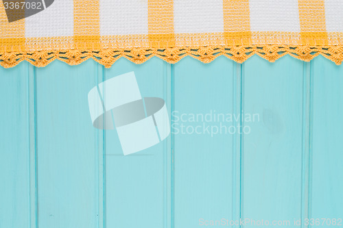 Image of White and yellow towel over wooden table