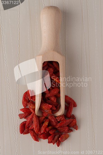 Image of Wooden scoop with dry red goji berries