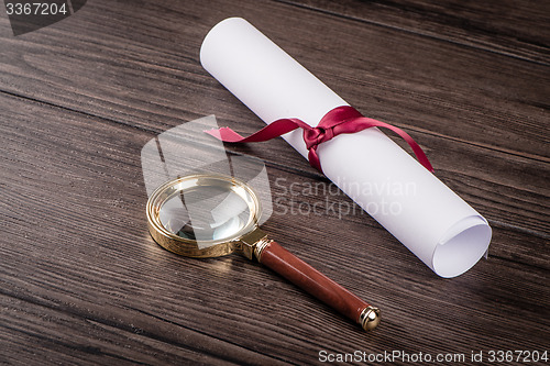 Image of Wrapped paper sheets and magnifying glass