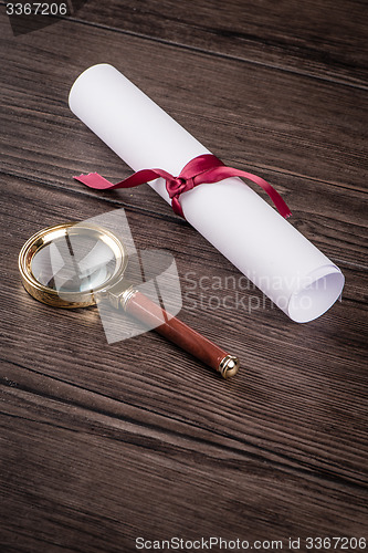 Image of Wrapped paper sheets and magnifying glass