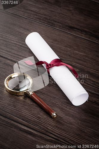 Image of Wrapped paper sheets and magnifying glass