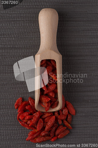 Image of Wooden scoop with dry red goji berries