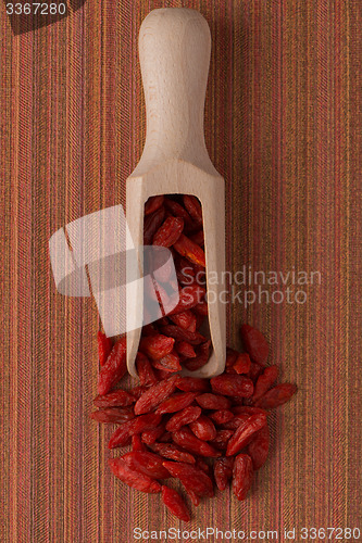 Image of Wooden scoop with dry red goji berries