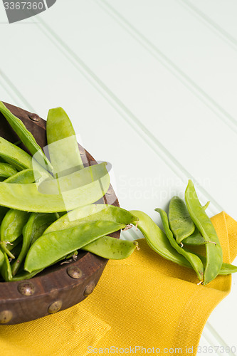 Image of Snow peas on wooden bowl