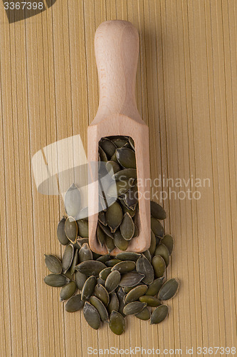 Image of Wooden scoop with pumpkin seeds