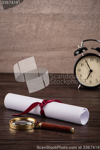 Image of Wrapped paper sheets and magnifying glass