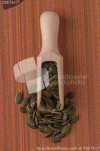 Image of Wooden scoop with pumpkin seeds