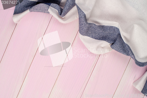 Image of White and blue towel over wooden table