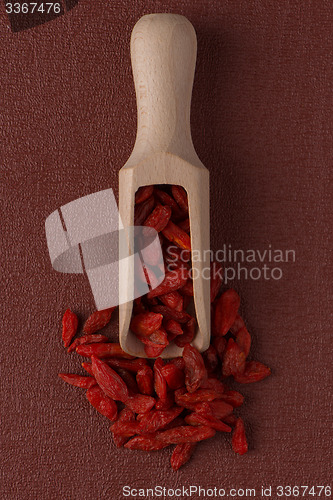 Image of Wooden scoop with dry red goji berries