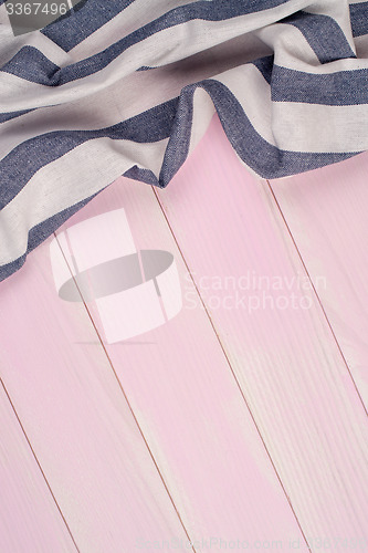 Image of White and blue towel over wooden table