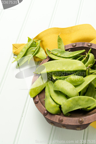 Image of Snow peas on wooden bowl