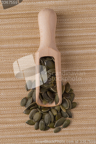 Image of Wooden scoop with pumpkin seeds