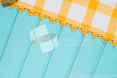 Image of White and yellow towel over wooden table