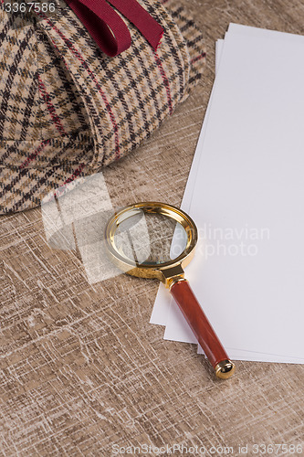 Image of Paper sheets and magnifying glass