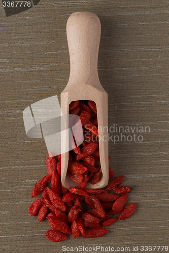 Image of Wooden scoop with dry red goji berries