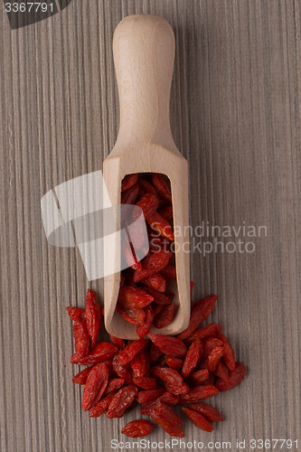 Image of Wooden scoop with dry red goji berries