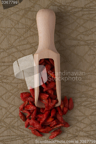 Image of Wooden scoop with dry red goji berries