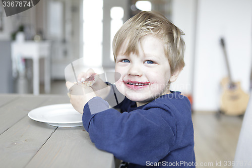 Image of Blond boy eats jam