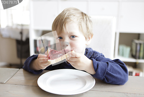 Image of Boy eating bread and jam