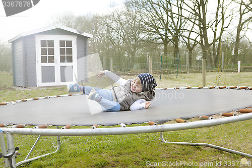 Image of Boy jumping on trampoline