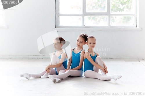Image of Three little ballet girls sitting and posing together