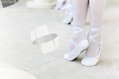 Image of Three little ballerinas dancing. legs in ballet flats close-up