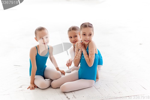 Image of Three little ballet girls sitting and talking together