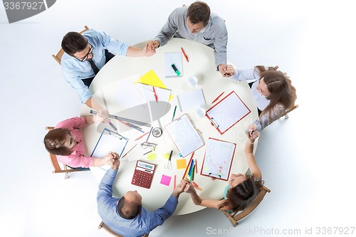 Image of Top view. United hands of business team on workspace background 
