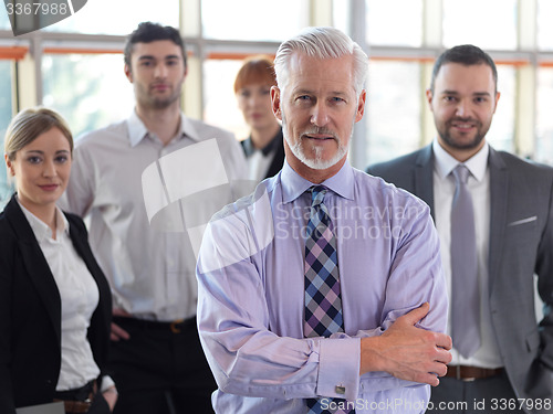 Image of senior business man with his team at office