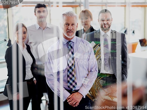 Image of senior business man with his team at office