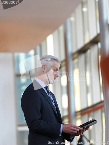 Image of senior business man working on tablet computer