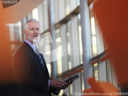 Image of senior business man working on tablet computer